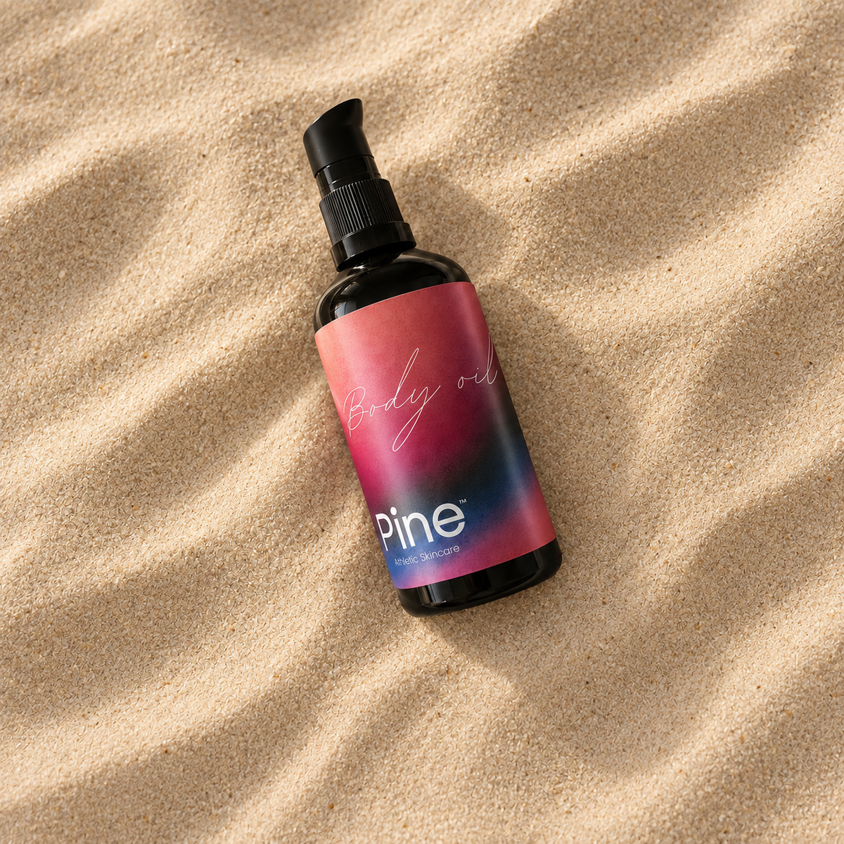 Pine Body Oil i flaske på bølget sand