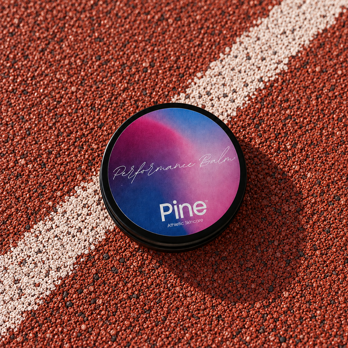 Pine Performance Balm i dåse på en rød løbebane